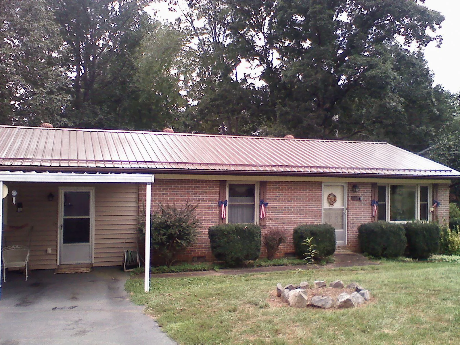 Bronze metal roof and carport on a brick ranch home — Roof Repair work by our crew in Muscatine