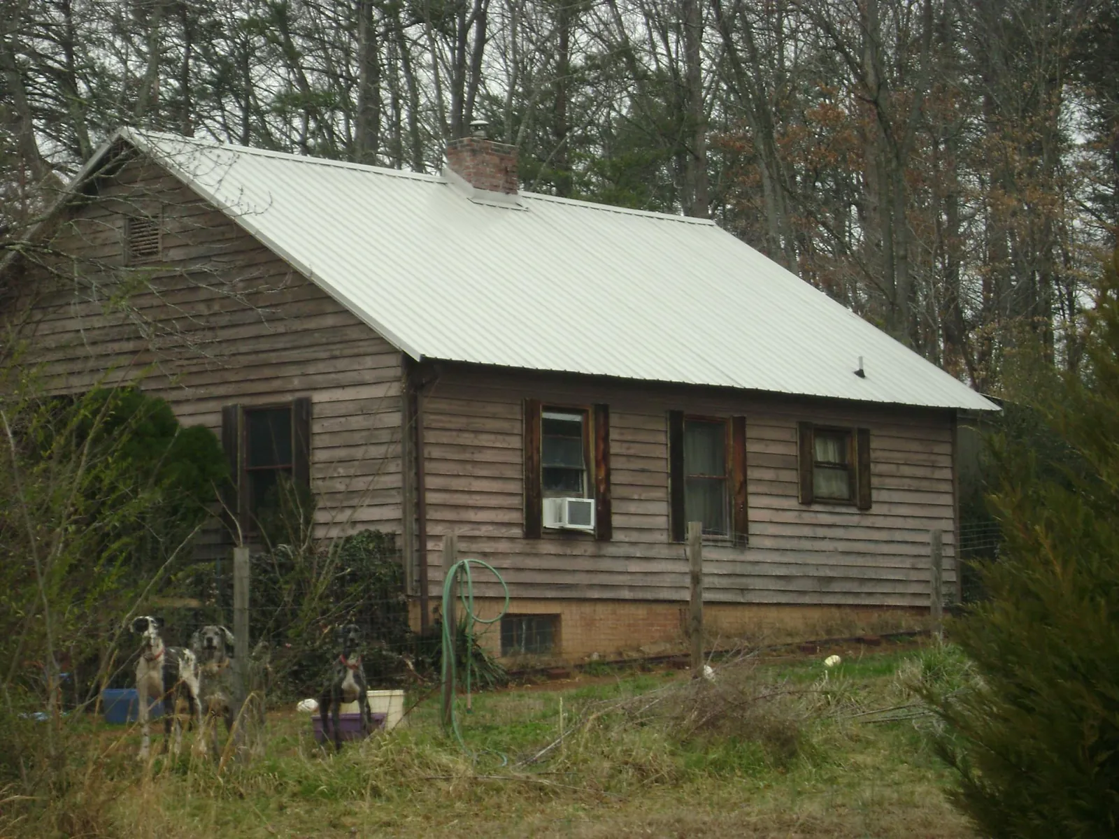 White metal roof on an old wood sided farmhouse, from a Metal Roof Installation job in Muscatine